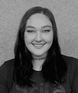 A black & white portrait of Stile team member Chelsea Page-Saxton smiling at the camera