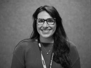 A black & white portrait of Stile team member Chloe Marie smiling at the camera