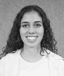 A black & white portrait of Stile team member Lavinia Monteiro smiling at the camera