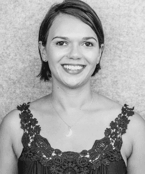 A black & white portrait of Stile team member Alexandra Russell smiling at the camera