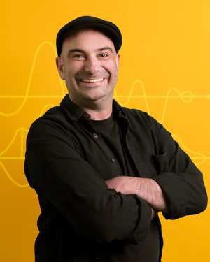 A black & white portrait of Stile team member Paul Giardina smiling at the camera