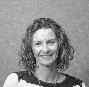 A black & white portrait of Stile team member Dimity Hately smiling at the camera