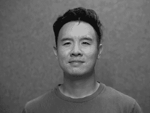 A black & white portrait of Stile team member Chris Hoang smiling at the camera