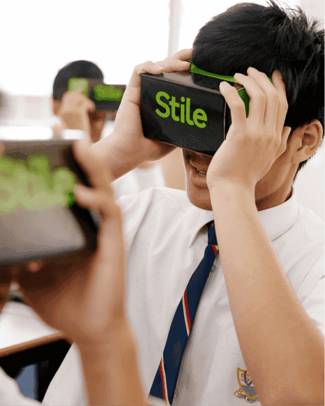 A student holds a VR headset up to their eyes