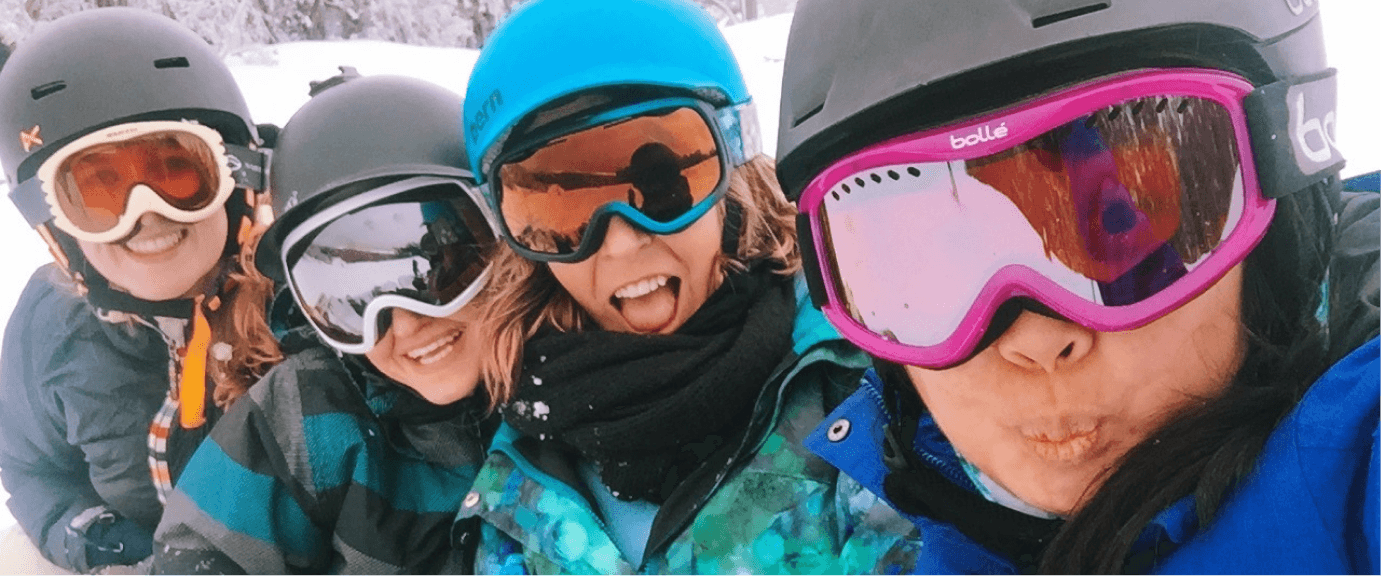 A selfie of four Stile team members wearing ski goggles and helmets