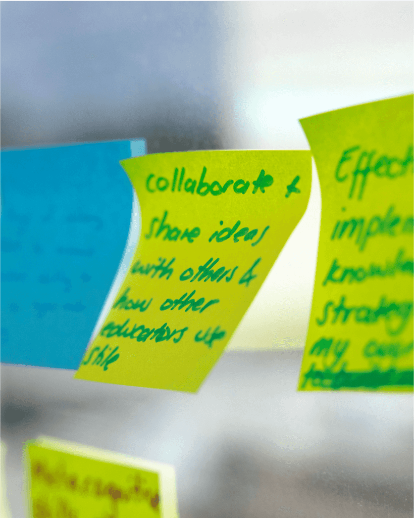 A handful of post-it notes on a window, with brainstorming ideas written on them