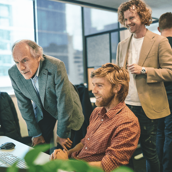 Three people looking at a screen