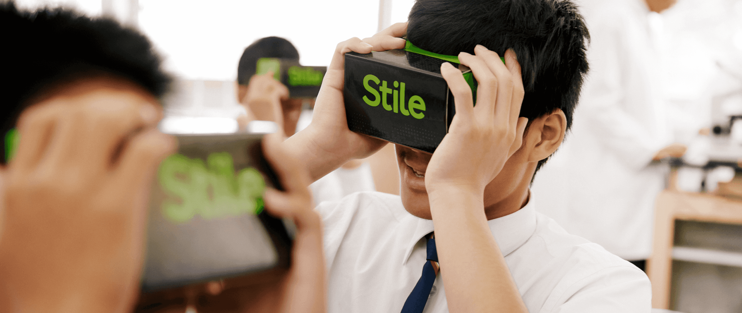 Several students holding Stile VR headsets up to their faces