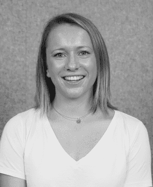 A black & white portrait of Stile team member Caitlyn Jones smiling at the camera