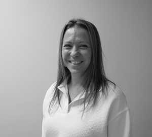 A black & white portrait of Stile team member Patty Luna smiling at the camera