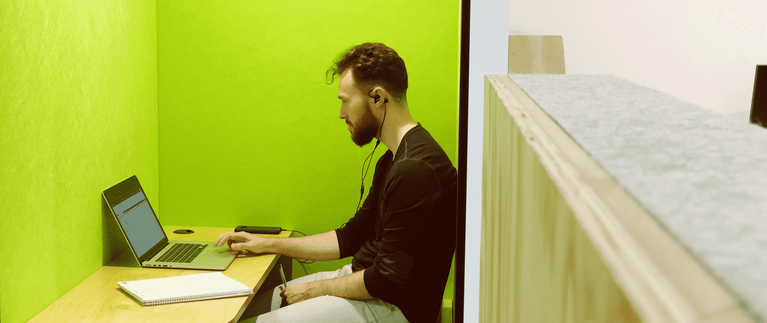 A software engineer wearing headphones working on a laptop