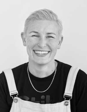 A black & white portrait of Stile team member Mel Horton smiling at the camera