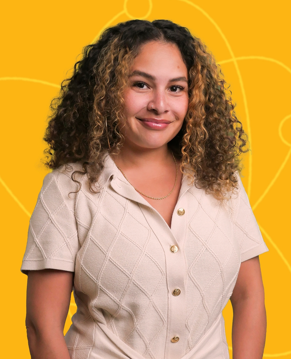 Person with curly hair wearing a cream-colored shirt, smiling in front of a bright yellow background with abstract science-themed line art.