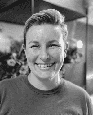 A black & white portrait of Stile team member Mel Horton smiling at the camera
