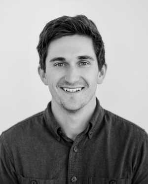 A black & white portrait of Stile team member Matt Hanlon smiling at the camera