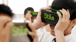 A student holds a VR headset up to their eyes